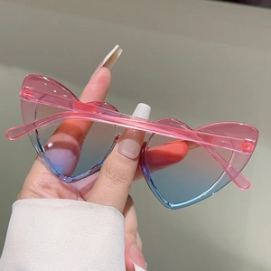 Close-up of pink and blue gradient heart-shaped sunglasses with clear resin frames