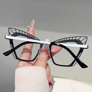 Détail macro de lunettes œil-de-chat avec décor ailé en métal et monture bicolore chic