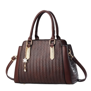 Dark brown tote bag with V-shaped woven pattern and golden floral charm pendant