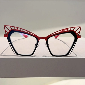 Détail de monture œil-de-chat avec motifs métalliques évidés bicolores rouge et noir
