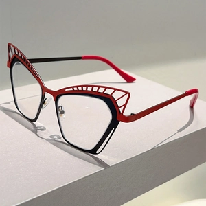 Gros plan de lunettes œil-de-chat en métal avec motifs évidés et design rouge et noir