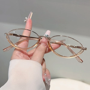 Close-up of hand holding rose gold metal oval glasses with transparent lenses