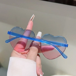 Détail de lunettes de soleil cœur sans monture avec des verres dégradés bleu et rose
