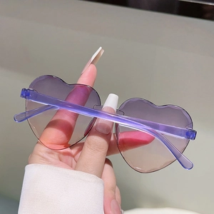 Détail de lunettes de soleil en cœur avec verres dégradés violets et bords ondulés