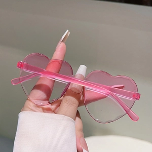 Gros plan détaillé de lunettes de soleil roses sans monture en forme de cœur pour fête
