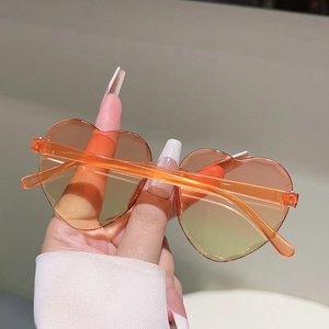 Détail de lunettes de soleil sans monture en forme de cœur avec verres dégradés orange