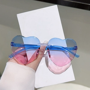 Détail de lunettes de soleil coeur sans monture avec verres dégradés rose et bleu