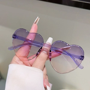 Détail de lunettes de soleil cœur sans monture avec verres dégradés violet-rose et branches