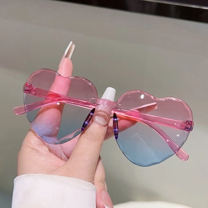 Détail de lunettes de soleil coeur sans monture avec verres dégradés rose et bleu