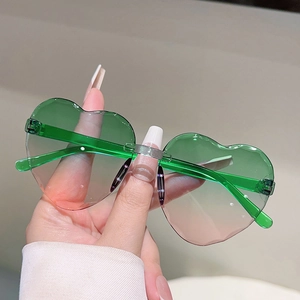 Gros plan de lunettes de soleil cœur sans monture avec verres dégradés vert et rose