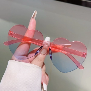 Close-up of heart-shaped rimless sunglasses featuring a pink and blue gradient lens