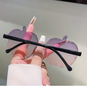Dettaglio di occhiali da sole per bambini senza montatura a forma di mela con lenti sfumate