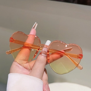 Gros plan de lunettes de soleil cœur sans monture avec verres dégradés orange
