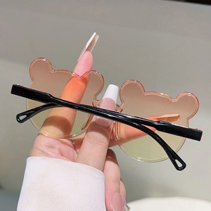 Détail de lunettes de soleil enfant en forme d'ours avec verres dégradés orange vifs