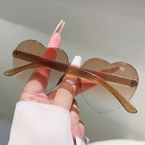 Detail shot of heart shaped frameless sunglasses with brown gradient lenses and slim temples
