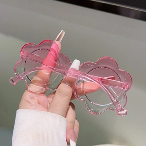 Détail de lunettes de soleil fleurs roses translucides avec finition en résine lisse