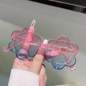 Détail gros plan de lunettes de soleil fleurs enfant avec verres dégradés rose et bleu