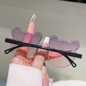 Détail de lunettes de soleil ours pour enfants avec verres dégradés roses et branches