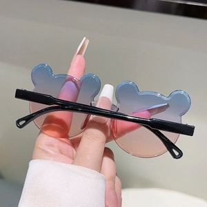 Détail des verres dégradés bleu-rose en forme d'oreilles d'ours pour lunettes enfant
