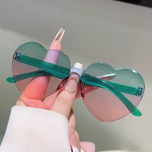 Detail of green and pink gradient heart-shaped rimless sunglasses with transparent temples