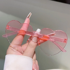Detailed macro view of pink heart-shaped frameless sunglasses with translucent texture