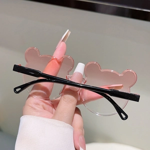 Détail de lunettes de soleil ours rose translucide pour enfants avec monture noire