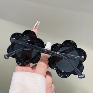 Gros plan détaillé des lunettes de soleil pour enfants en forme de fleur créative noire mate