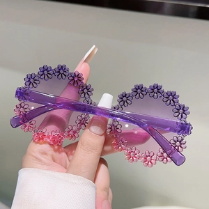 Macro shot of purple floral daisy decorations on round frame sunglasses for kids