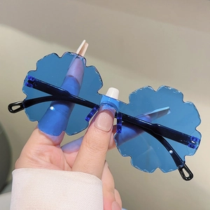 Close-up of blue flower-shaped rimless sunglasses with wavy petal edges and black temples