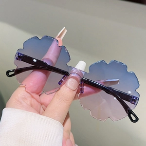 Detail of flower-shaped rimless sunglasses with pink-blue gradient lenses and wave edges