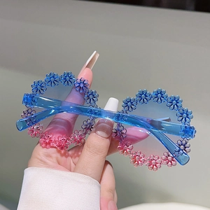 Detailed view of colorful daisy flower sunglasses with blue-pink gradient frames