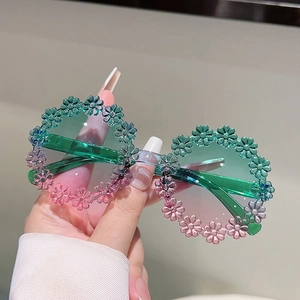 Detailed view of kids' round flower petal sunglasses with green and pink gradient finish