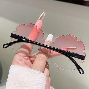 Detail of pink gradient flower-shaped rimless lenses on stylish children's sunglasses