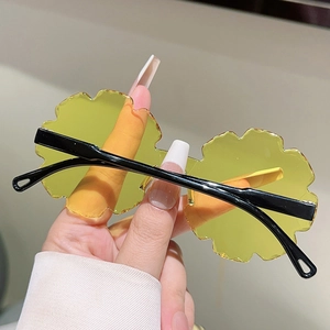 Detail of yellow flower-shaped rimless sunglasses with irregular wavy edges for children
