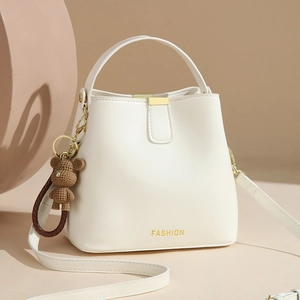 White bucket shoulder bag for women with leather texture and bear charm detail