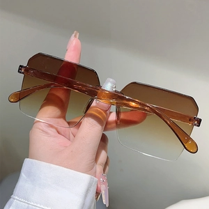 Close-up of rimless gradient jelly sunglasses with transparent amber temple detail