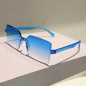Close-up of rimless square sunglasses with blue gradient lenses and transparent blue temples