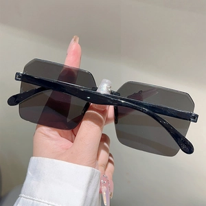 Close-up of oversized square frameless sunglasses with dark lenses and punk style