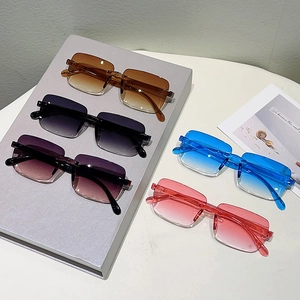 Vue à plat de lunettes de soleil sans monture dégradées en cinq couleurs sur un bureau