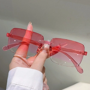 Détail des verres dégradés roses et des branches transparentes de lunettes sans monture