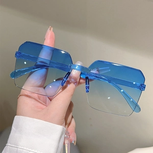 Detail of blue gradient lens and silver metal bridge on oversized frameless sunglasses