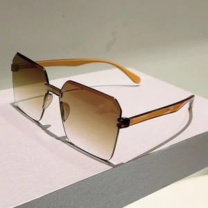 Detail view of brown gradient rimless sunglasses with geometric cut lenses and clear temples