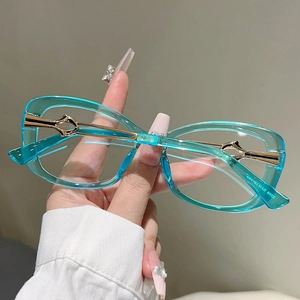 Close-up of mint green transparent frames with gold hollow metal temples for women