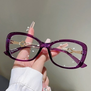 Detail view of purple resin frame with golden heart cutout metal temples and specs