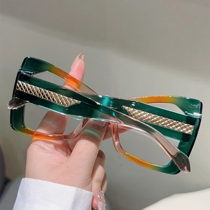Close-up of green and orange gradient glasses frame with gold diamond pattern metal detail
