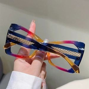 Close-up of cat-eye glasses with colorful gradient frame and gold diamond-pattern temples