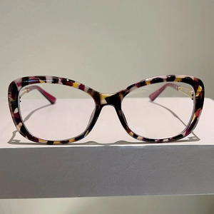 Detail of colorful tortoiseshell pattern frame and gold metal hinges on optical glasses
