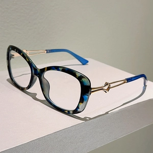 Cat eye glasses featuring blue tortoiseshell frames and gold hollow metal temples