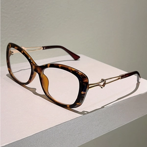 Detail of tortoiseshell frame glasses with golden twisted metal temples and high finish