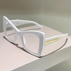 Detail of white cat-eye frames with signature gold woven metal texture on the temples